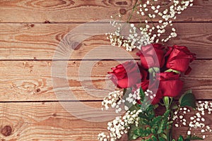 Valentine's day background with red roses on wooden table. View from above