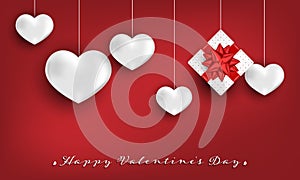 Valentine`s Day background of white gift box with red ribbon and white heart hanging on red background.