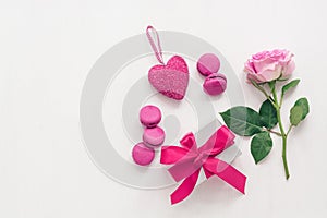 Valentine`s Day. Beautiful composition - roses, gift box, purple macaroons and heart. White painted wood background. Greeting car