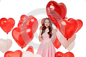 Valentine& x27;s day. Beauty girl holding red air balloons, symbols of love. Happy Young woman laughing. Model having fun