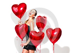 Valentine`s Day. Beauty girl with red heart shaped air balloons having fun