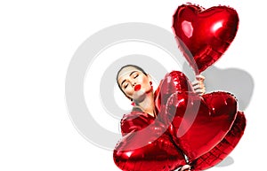 Valentine`s Day. Beauty girl with red heart shaped air balloons having fun, isolated on white