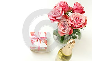 Valentine`s day, birthday background. Bouquet of pink roses flowers, gift box and champagne bottle isolated
