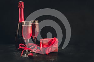 Valentine`s day and birthday greeting card with champagne and heart candy on black