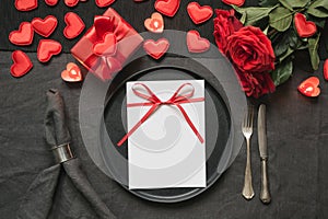 Valentine`s day or birthday dinner. Elegance table setting with red rose on black linen tablecloth