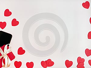 Valentine`s day card. Composition with mobile phone, gifts and red hearts on white surface. Top view. Space for text