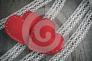 Valentine`s day card. Red felt heart on lace and wooden table background with copy space.