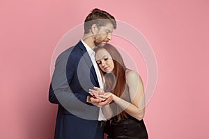 Valentine`s day celebration, happy caucasian couple isolated on coral background