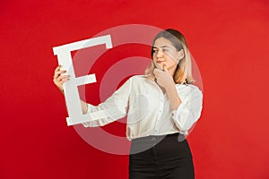 Valentine`s day celebration, happy caucasian girl holding letter on red background