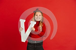 Valentine`s day celebration, happy caucasian girl holding letter on red background