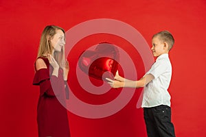 Valentine`s day celebration, happy caucasian kids isolated on red background