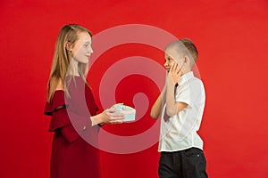 Valentine`s day celebration, happy caucasian kids isolated on red background