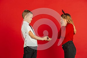 Valentine`s day celebration, happy caucasian kids isolated on red background