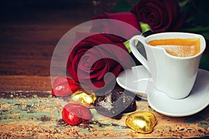 Valentine's day celebration with heart chocolate, coffee cup and roses on wooden background