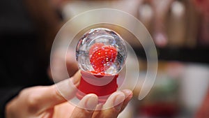 Valentine's Day. close-up. in hand. glass ball with a red heart and rainbow sparkles inside. romantic gift