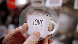 Valentine's Day. close-up. small coffee cup, writing love, in hands. gift on Valentine's Day, as an expression