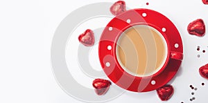 Valentine`s day composition with coffee cup and box of chocolate hearts on white background. Space for text.