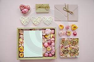 Valentine`s Day composition. Flat lay of white hearts, handmade gift boxes, craft paper, envelope, rose buds on pink background.