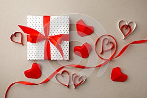 Valentine`s Day. Composition made of gift, origami hearts and ribbon on gray background. Valentines day background. Flat lay, top