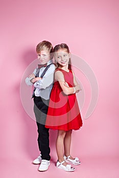 Valentine's Day concept..Cute smiling boy and girl standing on a pink background .