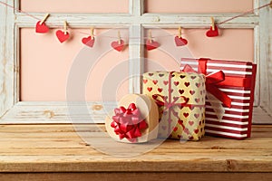 Valentine`s Day concept with gift boxes and heart shape garland on wooden table