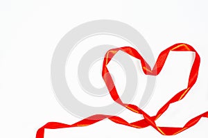 Valentine`s day concept. Heart made of bright red ribbon on a white background.
