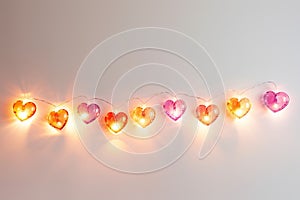 Valentine's Day concept. Lights in heart shape on white background. Place for text