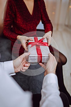 Valentine`s day concept. Loving couple give each other presents on 14 February. Romantic Boyfriend and girlfriend celebrating