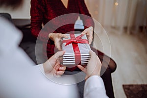 Valentine`s day concept. Loving couple give each other presents on 14 February. Romantic Boyfriend and girlfriend celebrating