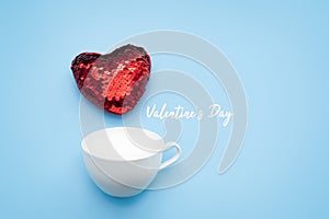 Valentine`s day concept. red heart with white coffee cup on blue background