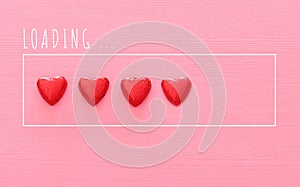 Valentine`s day concept. red Ã§hocolate hearts over pink wooden background. Love loading concept