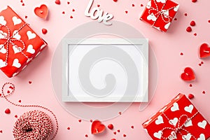 Valentine`s Day concept. Top view photo of gift boxes photo frame heart shaped candles inscription love spool of twine and