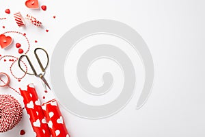 Valentine`s Day concept. Top view photo of wrapping paper rolls scissors heart shaped candles spool of twine adhesive tape and