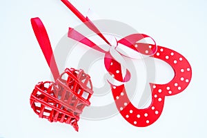 Valentine's day concept. Two red hearts. Wooden heart with white dots and a ribbon bow on a stick. Wicker heart with a