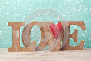 Valentine`s day concept with wooden letters love and heart shape over bokeh background