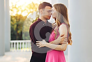 Valentine`s Day, couple in love, dating in the city outdoors. Romantic couple walking in the city holding hands