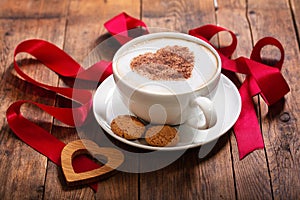 Valentine`s day. Cup of cappuccino coffee with heart on foam