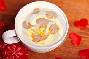 Valentine`s day. A Cup of cappuccino with a heart-shaped latte art on a wooden table. The concept of Declaration of love