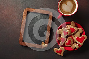 Valentine`s Day with a cup of coffee, a board, a heart-shaped cookie, a gift. Top view with copy space