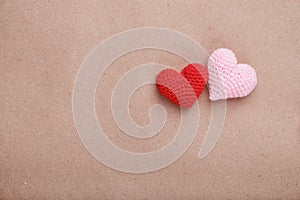 Valentine's day decorative background. Two handmade crochet hearts on craft paper.