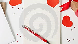 Valentine`s Day. Flat lay of red hearts, handmade gift boxes, love letter, notebook for writing on a white background. copy space
