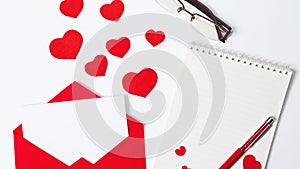 Valentine`s Day. Flat lay of red hearts, love letter, notebook for writing on a white background. copy space. The concept of