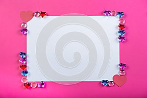 Valentine`s day frame on pink background made of pebbles in the shape of a heart with white space