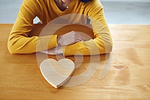 Valentine`s day. Girl with a wooden heart on the table