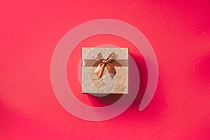 Valentine`s Day. Golden gift box on red background. Top view. Copy space. Festive backdrop for holidays: Birthday, Valentines day