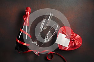 Valentine`s day greeting card with champagne glasses and candy hearts on stone background. Top view with space for your greetings