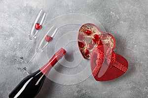 Valentine`s day greeting card with champagne glasses and candy hearts on stone background. Top view with space for your greetings