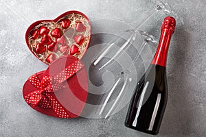 Valentine`s day greeting card with champagne glasses and candy hearts on stone background. Top view with space for your greetings