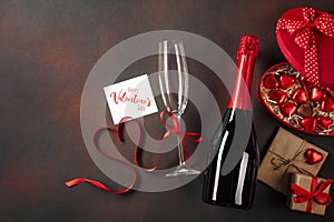 Valentine`s day greeting card with champagne glasses and love gift box on stone background. Top view with space for your greeting