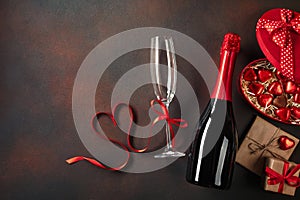 Valentine`s day greeting card with champagne glasses and love gift box on stone background. Top view with space for your greeting